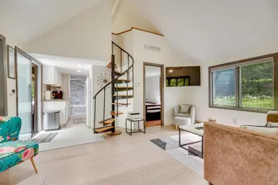 a living room with a spiral staircase in a house at South Salem Vacation Rental with Furnished Deck! in South Salem