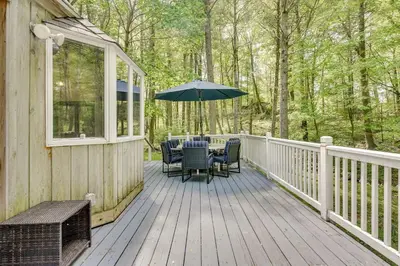 a deck with a table and chairs and an umbrella at South Salem Vacation Rental with Furnished Deck! in South Salem