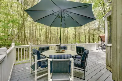 a table with chairs and an umbrella on a deck at South Salem Vacation Rental with Furnished Deck! in South Salem