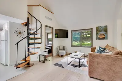 a living room with a staircase and a couch at South Salem Vacation Rental with Furnished Deck! in South Salem