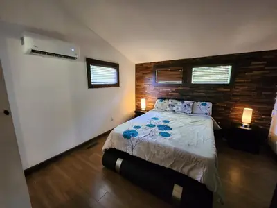 a bedroom with a bed and two windows at little cozy house in a village in Mountain Dale