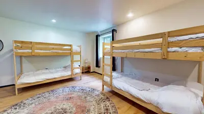 a room with two bunk beds and a rug at The Stone Mason - Large Modern Home on 5 Acres - 2 Hrs from NYC in Pond Eddy