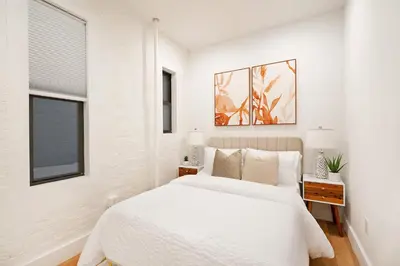 a white bedroom with a bed and a window at 1290-7 New Renovated 2 Bedrooms in UES in New York