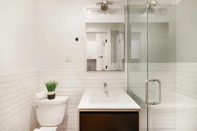 a bathroom with a toilet and a sink and a shower at 1290-7 New Renovated 2 Bedrooms in UES in New York