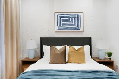 a bedroom with a bed with pillows and two lamps at 1290-7 New Renovated 2 Bedrooms in UES in New York