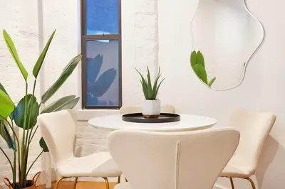 a white dining room with a white table and chairs at 1290-7 New Renovated 2 Bedrooms in UES in New York
