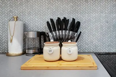 two containers of kitchen utensils sitting on a cutting board at 1290-7 New Renovated 2 Bedrooms in UES in New York