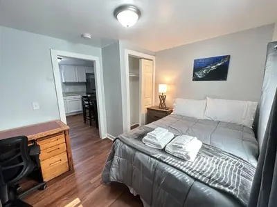 a bedroom with a bed and a desk and a kitchen at Home Plate Apt 2 All Star Baseball Rentals in Oneonta