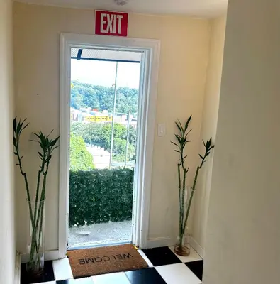 an exit sign in a hallway with two vases at 4-A Diamond in Yonkers in Yonkers