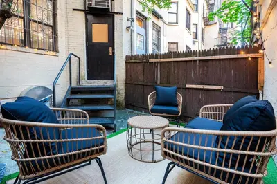 a patio with chairs and a table and a staircase at 74-1C New Studio With private outdoors - GYM in New York
