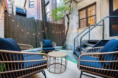 a patio with chairs and a table and a fence at 74-1C New Studio With private outdoors - GYM in New York