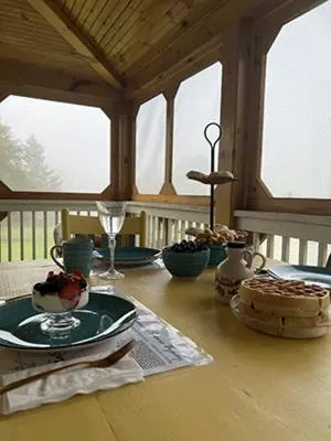 a wooden table with a plate of food on it at French Woods Farmhouse Bed & Breakfast in Hancock