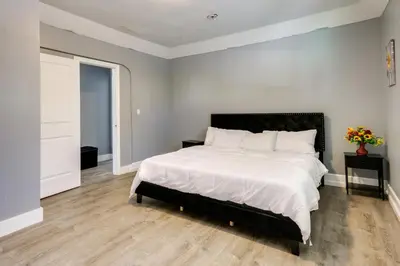 a bedroom with a large white bed with a black headboard at Chic Newark Vacation Rental 3 Mi to Airport! in Newark