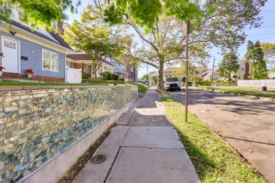 a sidewalk in front of a house with a wall at Chic Newark Vacation Rental 3 Mi to Airport! in Newark