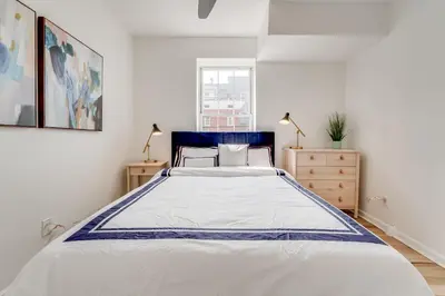 a white bedroom with a large bed and a window at Jersey City Monthly Boutique 20 Min to NYC in Jersey City