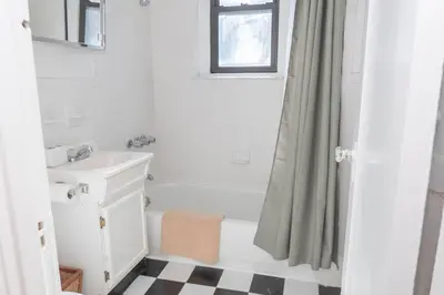 a bathroom with a white tub and a sink at Hoboken Haven – Heart of town! in Hoboken