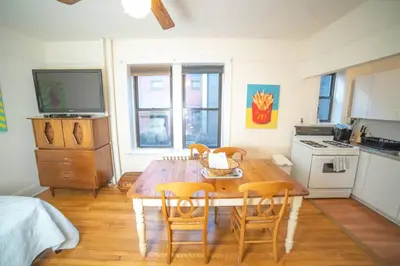 a kitchen with a wooden dining table and chairs at Cozy apartment in beautiful midtown Hoboken in Hoboken