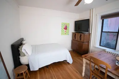 a bedroom with a bed and a tv and a table at Cozy apartment in beautiful midtown Hoboken in Hoboken