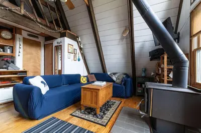 a living room with a blue couch and a stove at Sunday Hollow in Margaretville