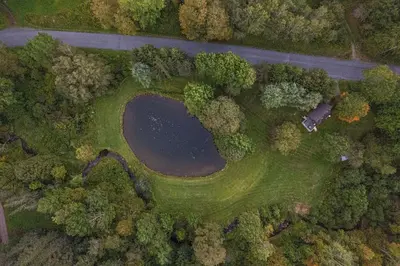 an aerial view of a field with a pond and a road at Sunday Hollow in Margaretville