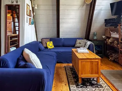 a blue couch in a living room with a table at Sunday Hollow in Margaretville