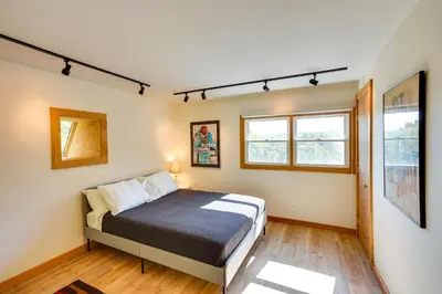 a bedroom with a bed and two windows at Charming Claverack Retreat with Serene Deck! in Claverack