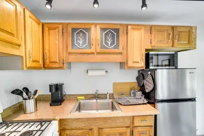 a kitchen with wooden cabinets and a stainless steel refrigerator at Charming Claverack Retreat with Serene Deck! in Claverack