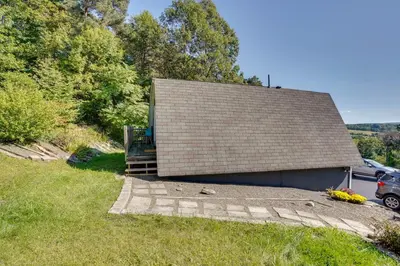 a building with a bench sitting next to a yard at Charming Claverack Retreat with Serene Deck! in Claverack