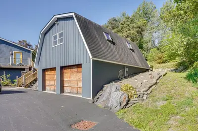 a gray house with two garage doors and a driveway at Charming Claverack Retreat with Serene Deck! in Claverack
