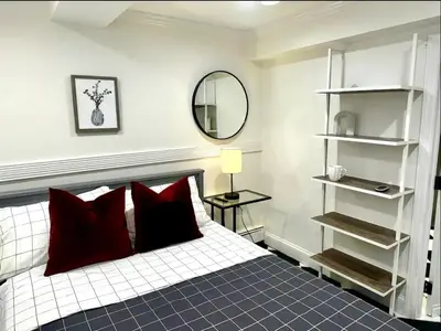 a bedroom with a bed with red pillows and a mirror at 5-A Diamond in Yonkers in Yonkers