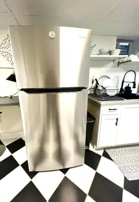 a stainless steel refrigerator in a kitchen with a checkered floor at 5-A Diamond in Yonkers in Yonkers
