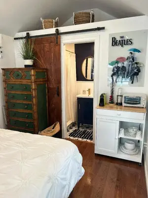 a bedroom with a bed and a dresser and a mirror at Adorable 1 bedroom cottage in Forest Hills