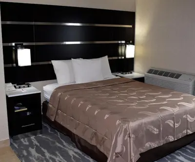 a hotel room with a large bed and two night stands at Quality Inn East Stroudsburg - Poconos in East Stroudsburg