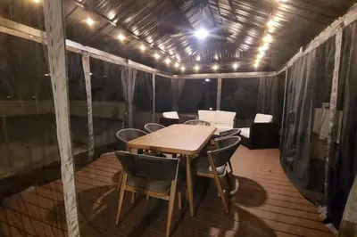 a table and chairs in a tent with lights at Luxury getaway in woods, Jacuzzi, Hot Tub, Pool in Bushkill