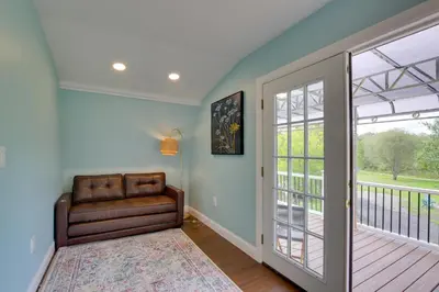 a living room with a couch and a sliding glass door at Fire Pit and On-Site Pond Hudson Valley Home! in Wappingers Falls