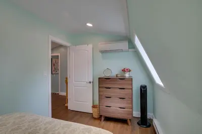 a bedroom with a bed and a dresser and a staircase at Fire Pit and On-Site Pond Hudson Valley Home! in Wappingers Falls