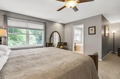 a bedroom with a large bed with a ceiling fan at Moondance Ridge Suites in New Paltz