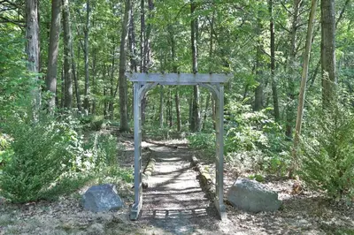 a wooden gate in the middle of a forest at Moondance Ridge Suites in New Paltz