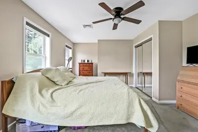 a bedroom with a bed and a ceiling fan at Moondance Ridge Suites in New Paltz