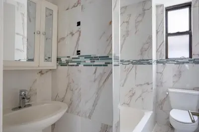 a white bathroom with a sink and a toilet at Midtown 2br w doorman wd nr Central Park NYC-1246 in New York