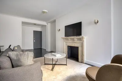 a living room with a fireplace and a flat screen tv at Midtown 2br w doorman wd nr Central Park NYC-1246 in New York