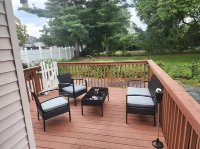 a wooden deck with chairs and a table on it at Comfortable home away from home in East Hartford