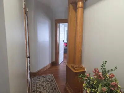 a hallway with a pillar and a plant on the floor at downtown and secluded in Manchester
