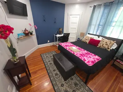 a bedroom with a bed and a vase of flowers at downtown and secluded in Manchester