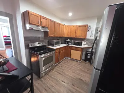 a kitchen with wooden cabinets and stainless steel appliances at downtown and secluded in Manchester