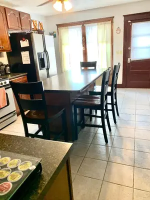a kitchen with a table and chairs and a refrigerator at Cozy First Floor Apartment in Chicopee