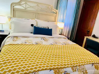 a bedroom with a large bed with a yellow comforter at Cozy First Floor Apartment in Chicopee