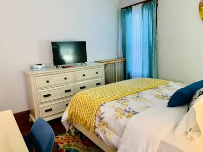 a bedroom with a bed and a tv on a dresser at Cozy First Floor Apartment in Chicopee