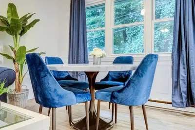 a dining room with blue chairs and a table at Premier League Pad in Manchester