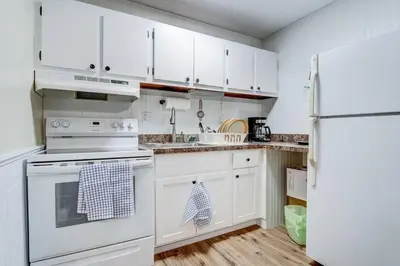 a kitchen with white cabinets and a white refrigerator at Premier League Pad in Manchester